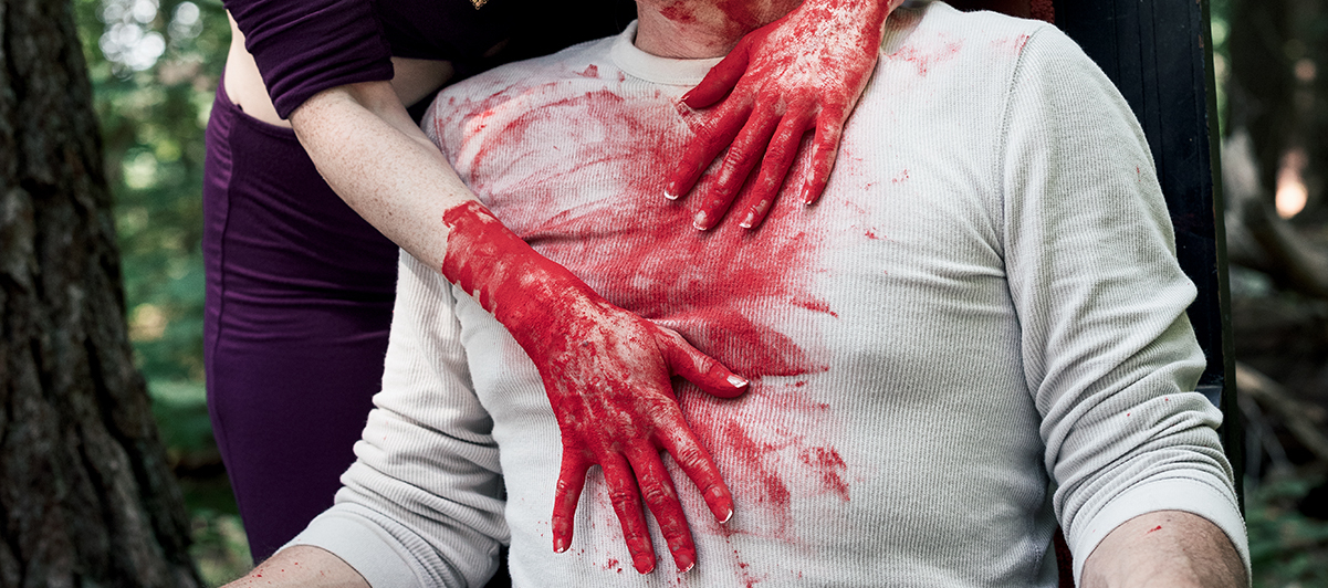 the bloodied hands of Lady Macbeth on Macbeth's chest, photo by Jeff Page Photography